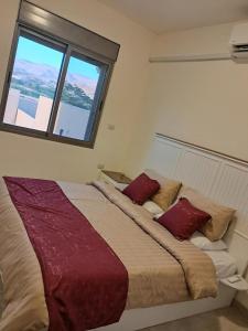 a large bed in a room with a window at Muzn al Ghaith Luxury Chalet with Private Pool in Ash Shāghūr +145 photos