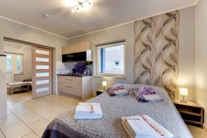 a bedroom with a bed with two towels on it at Villa Arkodes in Gdańsk