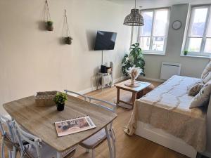 a living room with a table and a couch at Le Cocon Bohème, appartement chaleureux in Sarrebourg