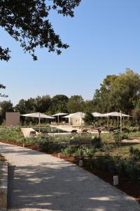 a park with tables and umbrellas on the side of a road at Quercia Private Nature Retreat in Maglie