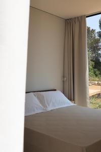 a bedroom with a bed and a window at Quercia Private Nature Retreat in Maglie