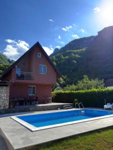 a house with a swimming pool in front of a mountain at Villa Pjene in Konjic