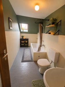 a bathroom with a tub and a toilet and a sink at Jagdhaus am Neubäuer See in Roding