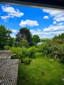 a view of a yard with trees and a lake at Jagdhaus am Neubäuer See in Roding
