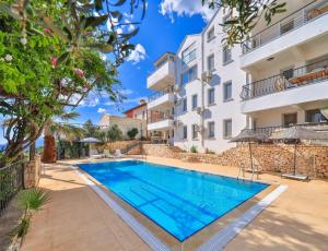 an apartment with a swimming pool in a building at Panaroma Meis Suits in Kaş