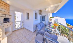 a balcony with a table and chairs and the ocean at Panaroma Meis Suits in Kaş