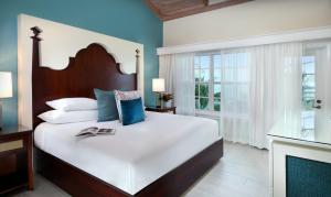 a bedroom with a large white bed and a fireplace at Ocean Key Resort & Spa, a Noble House Resort in Key West +55 photos