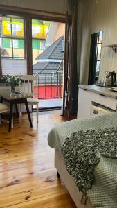 a room with a bed and a table and a kitchen at Jagienka in Łeba