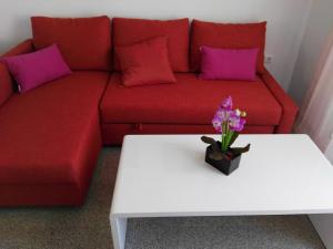 a red couch with purple pillows and a white table at Velez Nazari Cambriles in Lújar