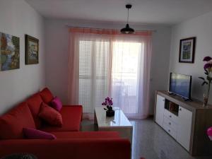 a living room with a red couch and a television at Velez Nazari Cambriles in Lújar