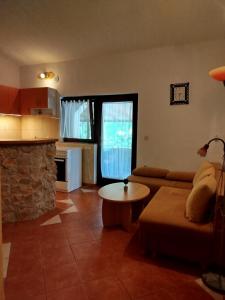 a living room with a couch and a table at Studio apartman Hrast in Seline +15 photos