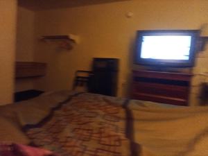 a bedroom with a bed and a flat screen tv at Knights inn hotel in Jacksonville