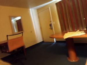 a room with a table and a chair and a door at Knights inn hotel in Jacksonville