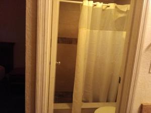 a shower with a white curtain in a bathroom at Knights inn hotel in Jacksonville