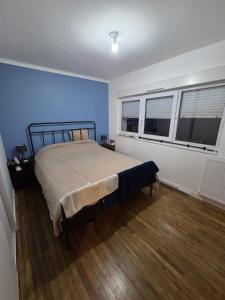 a bedroom with a bed with blue walls and two windows at Ti a mor in Carnac