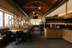 ein Restaurant mit Tischen und Stühlen in einem Raum mit Fenstern in der Unterkunft Malga Prefaè in Commezzadura