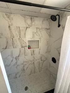 a shower with a white marble wall at The Cozy Corner House in Kissimmee +10 photos
