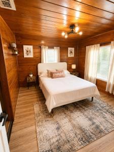 a bedroom with a large bed in a room with wooden walls at The Cozy Corner House in Kissimmee