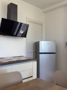 a small kitchen with a refrigerator and a table at Lentamente Domo in San Giovanni