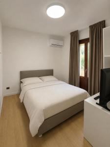 a bedroom with a large bed and a television at Lentamente Domo in San Giovanni