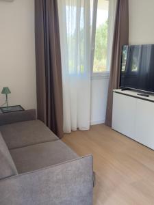 a living room with a couch and a flat screen tv at Lentamente Domo in San Giovanni