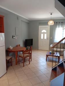 a kitchen and living room with a table and a tv at Amentas Luxury Apartments in Vrontádos