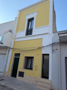 a yellow and white building with two windows at La dimora del borgo antico in Pulsano