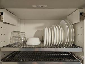 a kitchen with plates and glasses on a shelf at Comfort View Apartment in Liepāja