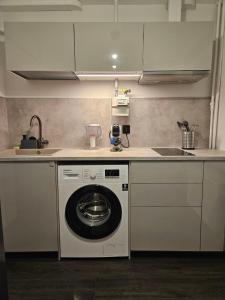 a kitchen with a washing machine and a sink at Comfort View Apartment in Liepāja +35 photos