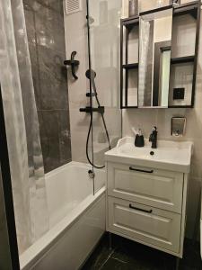 a white bathroom with a sink and a shower at Comfort View Apartment in Liepāja