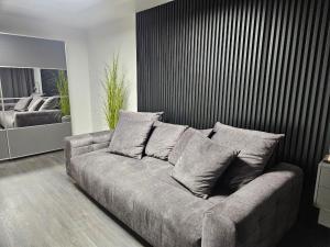 a living room with a couch with pillows on it at Comfort View Apartment in Liepāja
