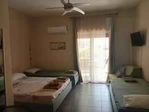 a bedroom with two beds and a ceiling fan at ELENAs in Kallithea Halkidikis