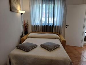 a bedroom with two beds with pillows on it at Luna in Novara