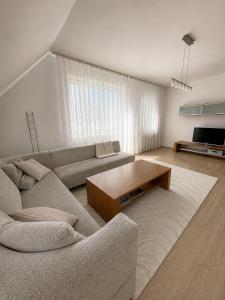 a living room with a couch and a coffee table at Veľký rodinný apartmán s výhľadom na zeleň a hory v centre Piešťan s parkovaním in Piešťany