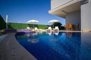 a swimming pool with chairs and umbrellas in a house at Huma Elite Hotel in Antalya
