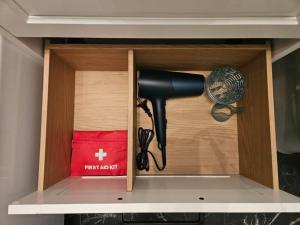 a hair dryer in a cabinet in a kitchen at Comfort View Apartment in Liepāja