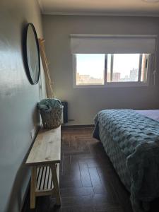 a bedroom with a bed and a mirror and a table at NAT home in San Lorenzo
