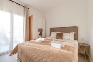 a bedroom with a large bed with towels on it at Apartmani Oleander in Bar