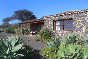 a stone house with a garden in front of it at Casa Las Caracolas in Mazo