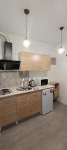 a kitchen with wooden cabinets and a white refrigerator at Жилье у моря in Odesa