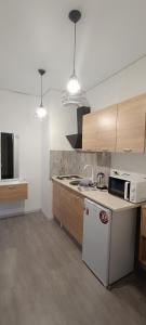 a kitchen with a stove and a white refrigerator at Жилье у моря in Odesa