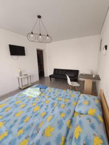 a bedroom with a bed with a blue blanket with yellow leaves at Жилье у моря in Odesa