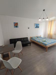 a living room with a bed and a table and chairs at Жилье у моря in Odesa