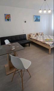 a living room with a bed and a table and a chair at Жилье у моря in Odesa +1 photo