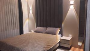 a bedroom with a bed with lights on the wall at Agel Inn Apartments Mavrovo in Mavrovo