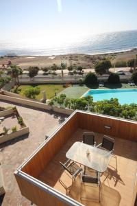- un balcon avec une table et deux chaises et une piscine dans l'établissement Apartment El Medano Sunrises, à El Médano