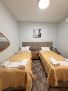 a room with two beds with yellow blankets on them at Terra Kampos Chios in Chios