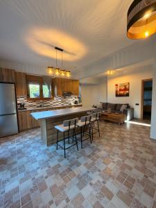 a large room with a kitchen and a bar with chairs at Terra Kampos Chios in Chios