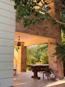 a patio with a wooden bench under a brick wall at Terra Kampos Chios in Chios