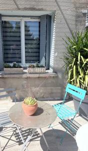 a table with a potted plant on it next to two chairs at Le studio signature in Vedène